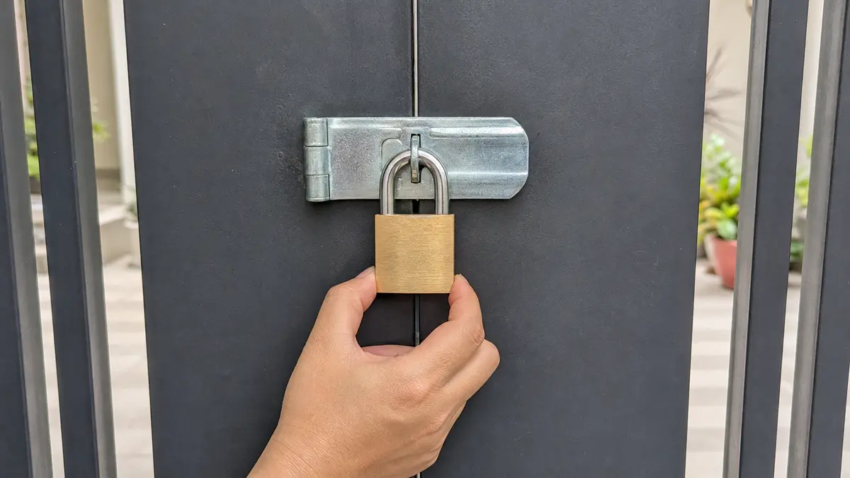 Bàn tay kéo nhẹ thân ổ khóa để kiểm tra chốt đã đóng